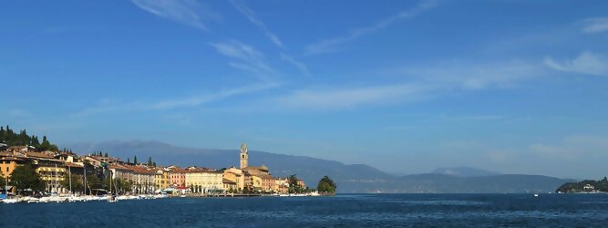 Aktiv beliebte Urlaubsziele am Gardasee -  Mit einer Fläche von 370 km² ist der Gardasee der größte See Italiens. Es liegt am Fuße der Alpen und erstreckt sich über drei Staaten: Lombardei, Venetien und Trentino. Die maximale Tiefe des Sees beträgt 346 m, er hat eine längliche Form und sein nördliches Ende ist sehr schmal. Dort ist der See von den Bergen der Gruppo di Baldo umgeben. Du trittst aus deinem gemütlichen Hotelzimmer und es begrüßt dich die warme italienische Sonne. Du blickst auf den atemberaubenden Gardasee, der in zahlreichen Blautönen schimmert - von tiefem Dunkelblau bis zu funkelndem Türkis. Majestätische Berge umgeben dich, während die Brise sanft deine Haut streichelt und der Duft von blühenden Zitronenbäumen deine Nase kitzelt. Du schlenderst die malerischen, engen Gassen entlang, vorbei an farbenfrohen, blumengeschmückten Häusern. Vereinzelt unterbricht das fröhliche Lachen der Einheimischen die friedvolle Stille. Du fühlst dich wie in einem Traum, der nicht enden will. Jeder Schritt führt dich zu neuen Entdeckungen und Abenteuern. Du probierst die köstliche italienische Küche mit ihren frischen Zutaten und verführerischen Aromen. Die Sonne geht langsam unter und taucht den Himmel in ein leuchtendes Orange-rot - ein spektakulärer Anblick.